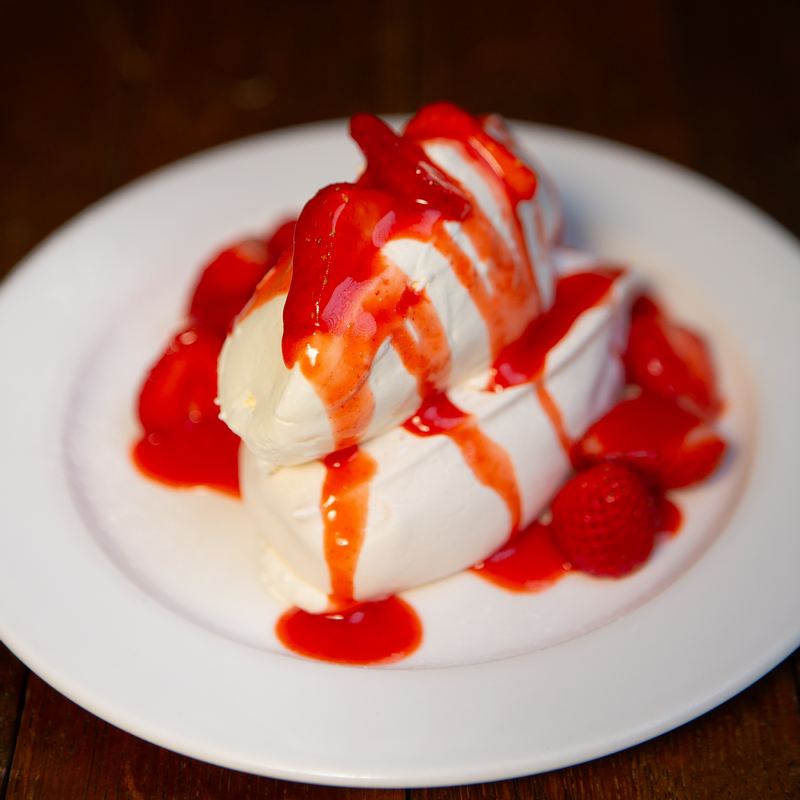 Meringue and cream with strawberries and strawberry sauce