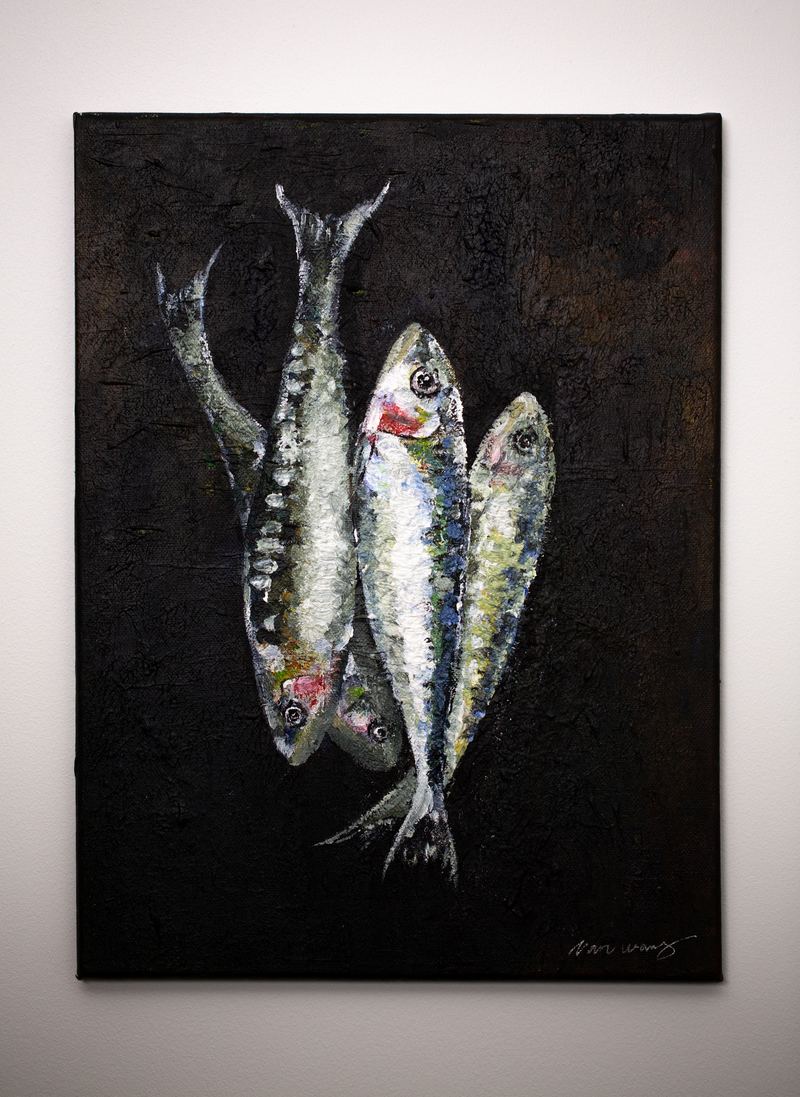 Painting of three sardines hanging on the restaurant wall